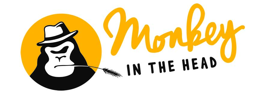 Monkey in the Head Logo mit Affenlogo. Der Affe trägt einen Hut. Der Schriftzug ist gelb und schwarz.